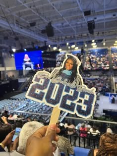 a person holding up a sticker in front of an audience