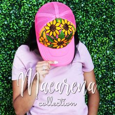 a woman wearing a pink hat with sunflowers on it and the words maedrena collection