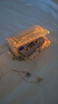 an old cassette player laying on top of a white sheet