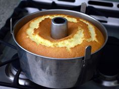 a bundt cake sitting on top of a stove next to a pan filled with batter