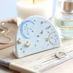 a small white heart shaped object sitting on top of a wooden table next to a candle