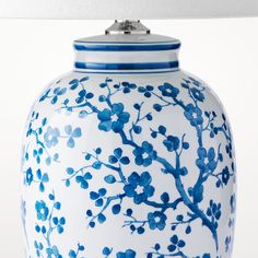 a blue and white vase sitting on top of a table next to a light fixture