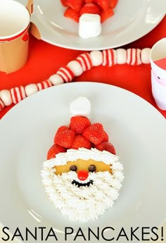 there is a santa cake on the plate with strawberries in front of it that says santa pancakes