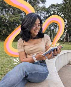 a woman sitting on a bench holding a book and smiling at the camera while reading