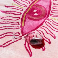 a wine glass sitting on top of a pink rug