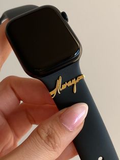 a person holding an apple watch with the word happy written on it's side