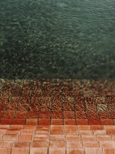 an aerial view of the water and brick walkway