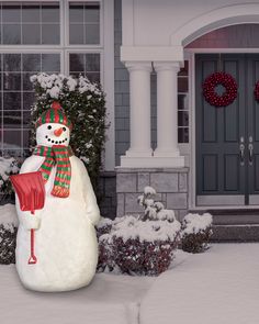 a snowman is standing in front of a house