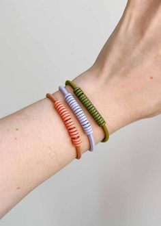 three different colored bracelets on someone's arm