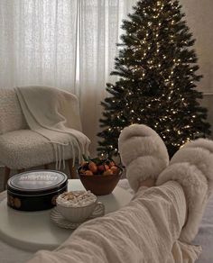 a living room with a christmas tree, bowl of fruit and an angel wings blanket