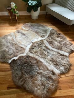 Size: 74” x 70” Truly one-of-a-kind. Made from six beige ivory sheepskin pelts, professionally sewn to last a life-time. Use this as a throw, blanket, couch cover, rug, bed cover, and more. Hair type: The fur on each of these pelts is soft, plush and has different textures and lengths throughout. The color is a natural ivory. Each pelt is exclusive and one-of-a-kind. There's never a duplicate!The Benefits of Sheepskins:- Wool is incredible at regulating body heat- Helps to relieve aches and pains- Resistant to dirt and bacteria- Hypo-allergenic (and help soothe skin rashes like eczema and more )- Adds warmth and texture to your homeOur ethically sourced pelts come from small organic farmers whose sheep roam miles each day through hilltops and mountains. They are softened with animal fats a Bear Skin Rug Crochet, Sheepskin Rug On Hearth, Fireplace Mantle Fur Rug, Log Slice Long Kitchen Bench With Fur Rug, Brown Sheepskin Rug In Bedroom, Sheepskin Rug Cabin, Bear Sheepskin Fabric, Blanket Couch Cover, Sheepskin Blanket