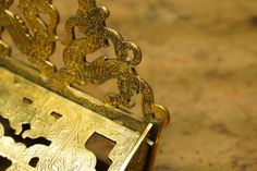 an ornate gold metal object sitting on top of a wooden table