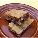 two pieces of dessert sitting on top of a brown plate