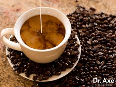 a cup of coffee is sitting on some coffee beans with a stick sticking out of it