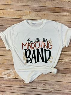 a white t - shirt that says i'm with the marching band on it