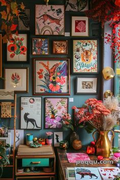 a room filled with lots of framed pictures and flowers on the wall next to a table