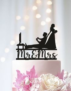 a wedding cake topper with a bride and groom silhouette on it's side