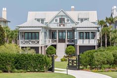 a large white house sitting on top of a lush green field