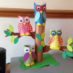 three paper owls sitting on top of a tree