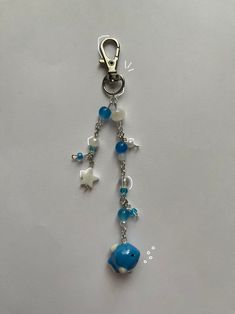 a blue and white beaded keychain hanging from a chain