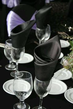 the table is set with wine glasses and napkins