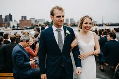 a bride and groom walking down the aisle at their wedding ceremony in front of an outdoor crowd