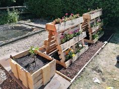 several wooden planters filled with flowers and dirt