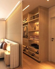 a room with a couch, closet and shelves filled with shoes on the floor next to a window