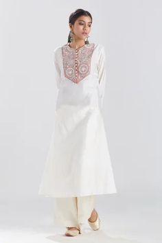 Ivory straight tunic with a contrast hand embroidered panel on the yoke and cuffs. Component: 1 Pattern: Embroidery Type Of Work: Thread and Beads Neckline: Round Sleeve Type: Full Fabric: Silk Chanderi Color: Ivory Other Details:  Cuffs with loop buttons Contrast panel on the yoke and cuffs Closure: Loop button front Note: Pant worn by the model is not for sale Disclaimer: Variations in fabric caused during the hand-weaving process  are not to be treated as defects. Occasion: Work - Aza Fashion Beaded Neckline, Ivory Silk, Pattern Embroidery, Weaving Process, Womens Tunics, Not For Sale, Color Ivory, Embroidery Thread, Aza Fashion