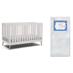 a baby crib next to a white mattress with a blue label on the side