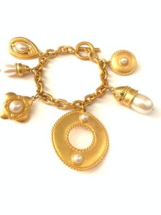 "Vintage Byzantine Revival Moghul Pearl Charm Medallion Bracelet // Chunky Gold Plated Charm Bracelet Gorgeous vintage gold plated charm bracelet. It has a smooth satin matte plated finish with 6 large chunky charms. The largest charm measures 1 5/8\", the little coin charm with faux pearl measures 7/8\" and the smallest charm, the little pearl measures 3/8\" x 7/8\". The bracelet is new old stock vintage from the 1980s so aside from some minor wear from being in storage (small dings/light scuff Chunky Gold Bracelet, Puffy Heart Charms, Victorian Gold, Small Charms, Gold Chain Jewelry, Large Jewelry, Bracelet Vintage, Pearl Charms, Short Necklace