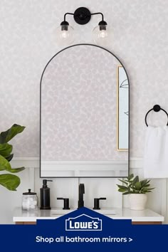 a bathroom mirror sitting above a sink under a faucet mounted on a wall