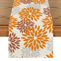 an orange and gray table runner with flowers on it