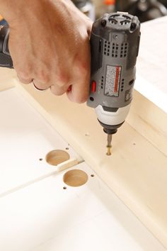 a person using a drill to attach holes in wood