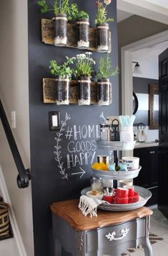 a kitchen with chalkboard on the wall and flowers in vases hanging above it