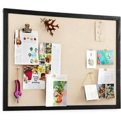 a bulletin board with magnets and pictures on it, hanging on the wall next to a pair of scissors