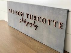 a metal sign that says,'allison turcotte photography'on the side of a wall