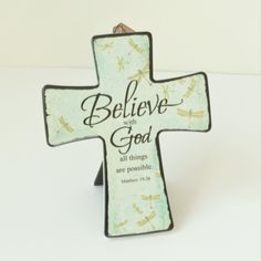 a cross with the words believe with god on it and dragonflies all over it