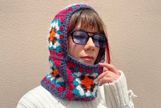 Stay cozy and stylish during the colder months with our handmade Granny Square Balaclava. Each balaclava is meticulously crafted with a unique combination of colors, including vibrant orange, earthy brown, crisp white, refreshing turquoise, and delicate pink. The addition of fluffy white yarn introduces a captivating texture to this one-of-a-kind accessory. We take pride in sourcing our materials responsibly, and for this particular balaclava, we have carefully selected yarn from a local shop that specializes in deadstock. By repurposing these high-quality materials, we not only create a fashionable accessory but also contribute to sustainable and eco-friendly practices. The Granny Square Balaclava is expertly crocheted with attention to detail, ensuring a snug and comfortable fit. The cla Handmade Balaclava For Winter Cold Weather, Handmade Balaclava For Cold Weather Winter, Handmade Balaclava For Winter, Handmade Winter Balaclava For Cold Weather, Crochet Full Face Balaclava For Winter, Handmade Fitted Balaclava For Winter, Handmade Fitted Winter Balaclava, Handmade Fitted Crochet Hat For Winter, Handmade Fitted Crochet Winter Hat