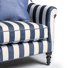 a blue and white striped chair with pillows on it