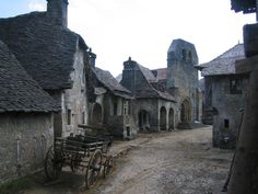 an old village with stone buildings and wooden carriages