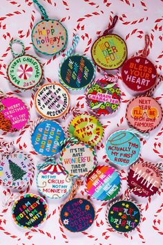 a bunch of badges that are sitting on a red and white tablecloth with confetti all over them