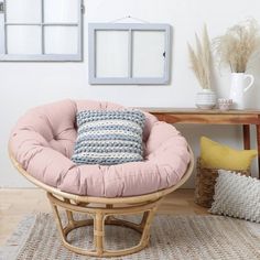 a chair with a pillow on it in front of a table and some other items