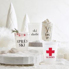 three different types of cups on top of a white surface with rocks and snow around them