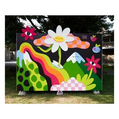 a large colorful painting on the side of a building with flowers and plants painted on it