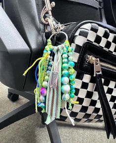 a black and white checkered bag with colorful beads hanging from it's handle