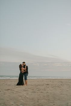 a man and woman embracing on the beach