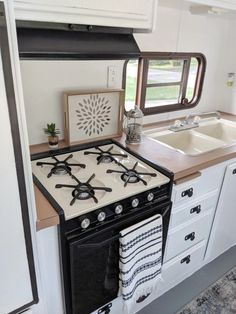 a stove top oven sitting inside of a kitchen next to a sink and countertop