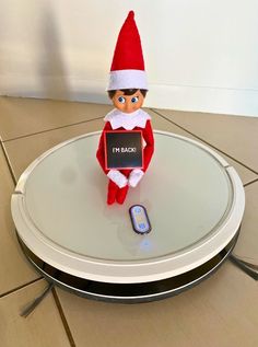 an elf is sitting on top of a table with a cell phone in front of it