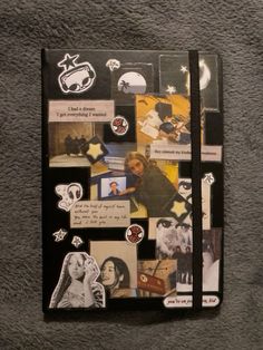 a notebook covered in pictures and writing on top of a gray surface with stars around it